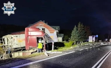 Nocna akcja służb przy uszkodzonej ciężarówce, która zjechała z drogi i uderzyła w budynek.